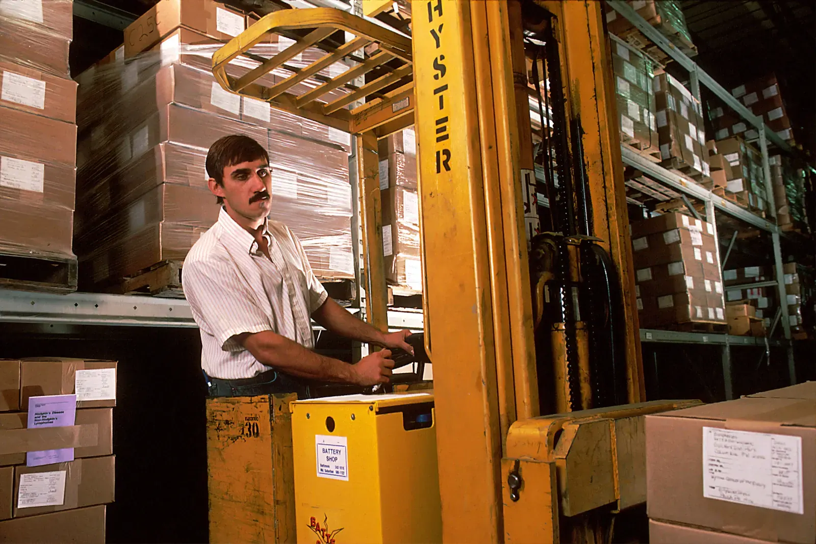 A forklift operator moves cases in a wine warehouse