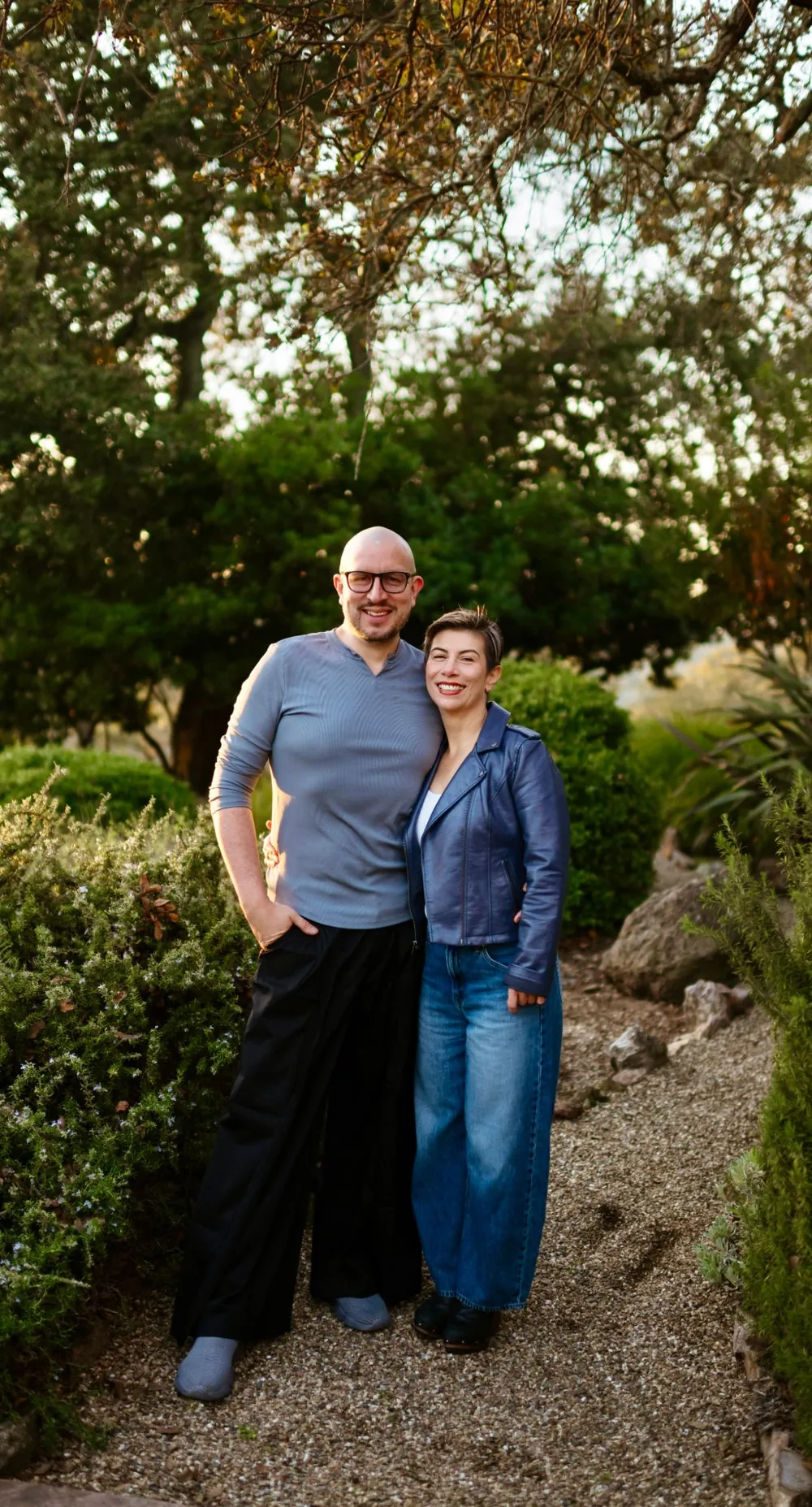 Alexander Torrenegra and Tania Zapata standing in a garden among oaks