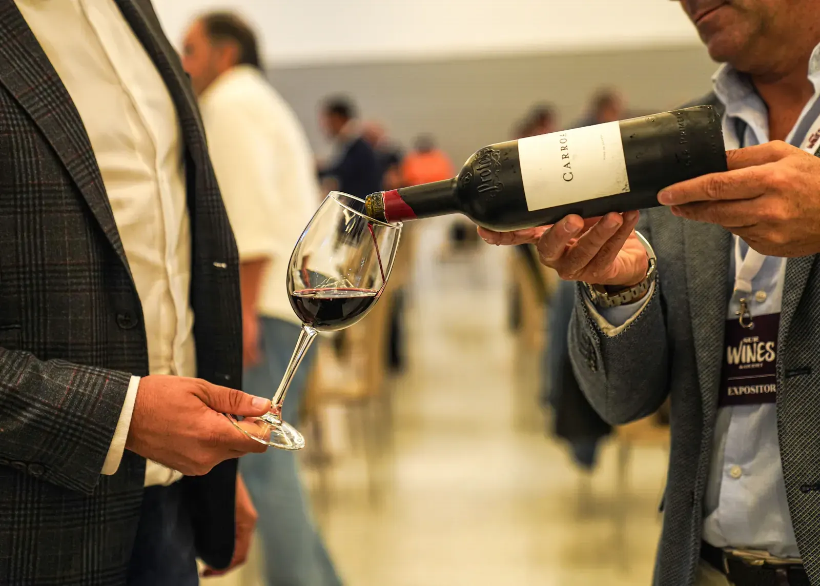 A sommelier pours red wine for a guest