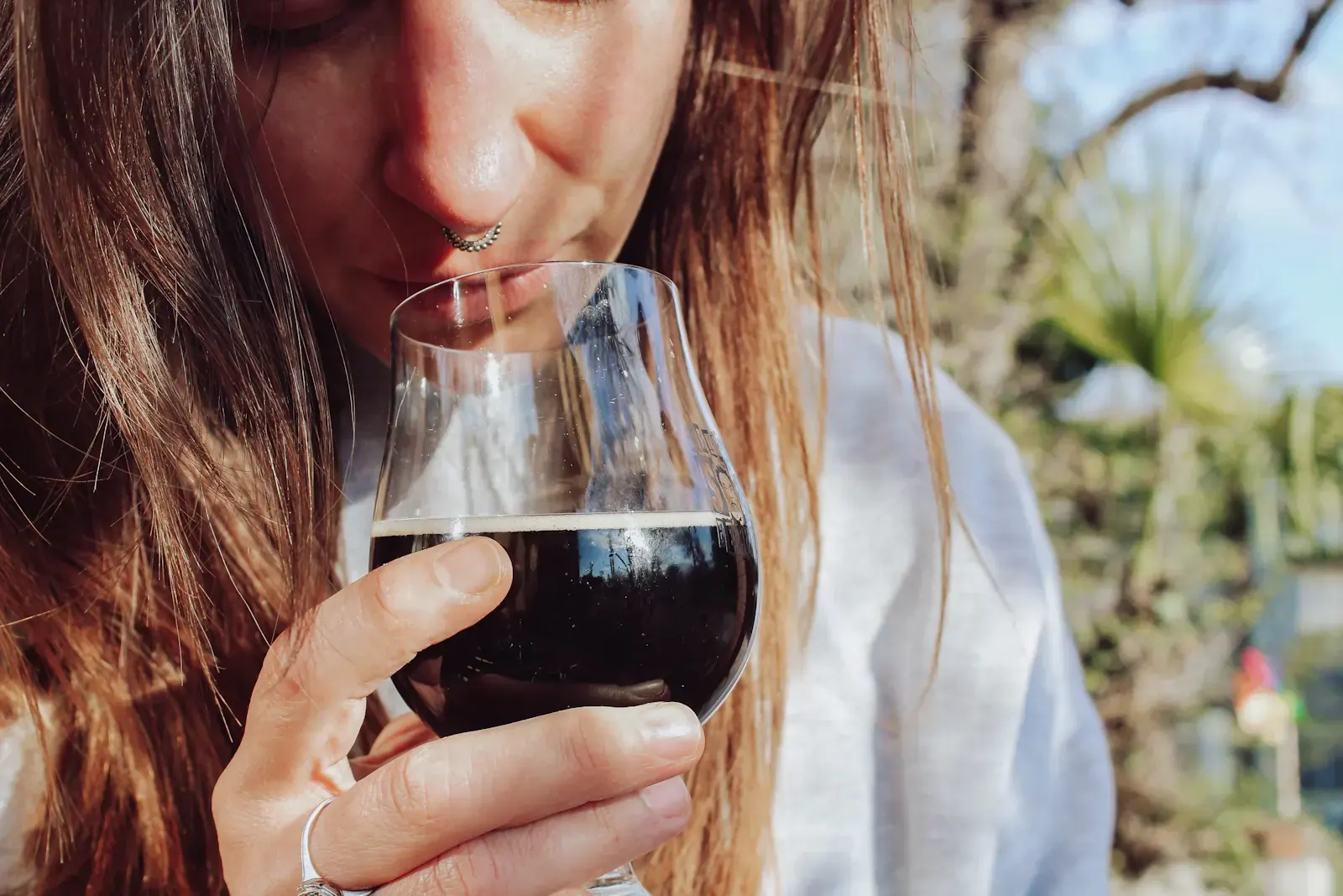 A guest smells a glass of red wine in a tasting room