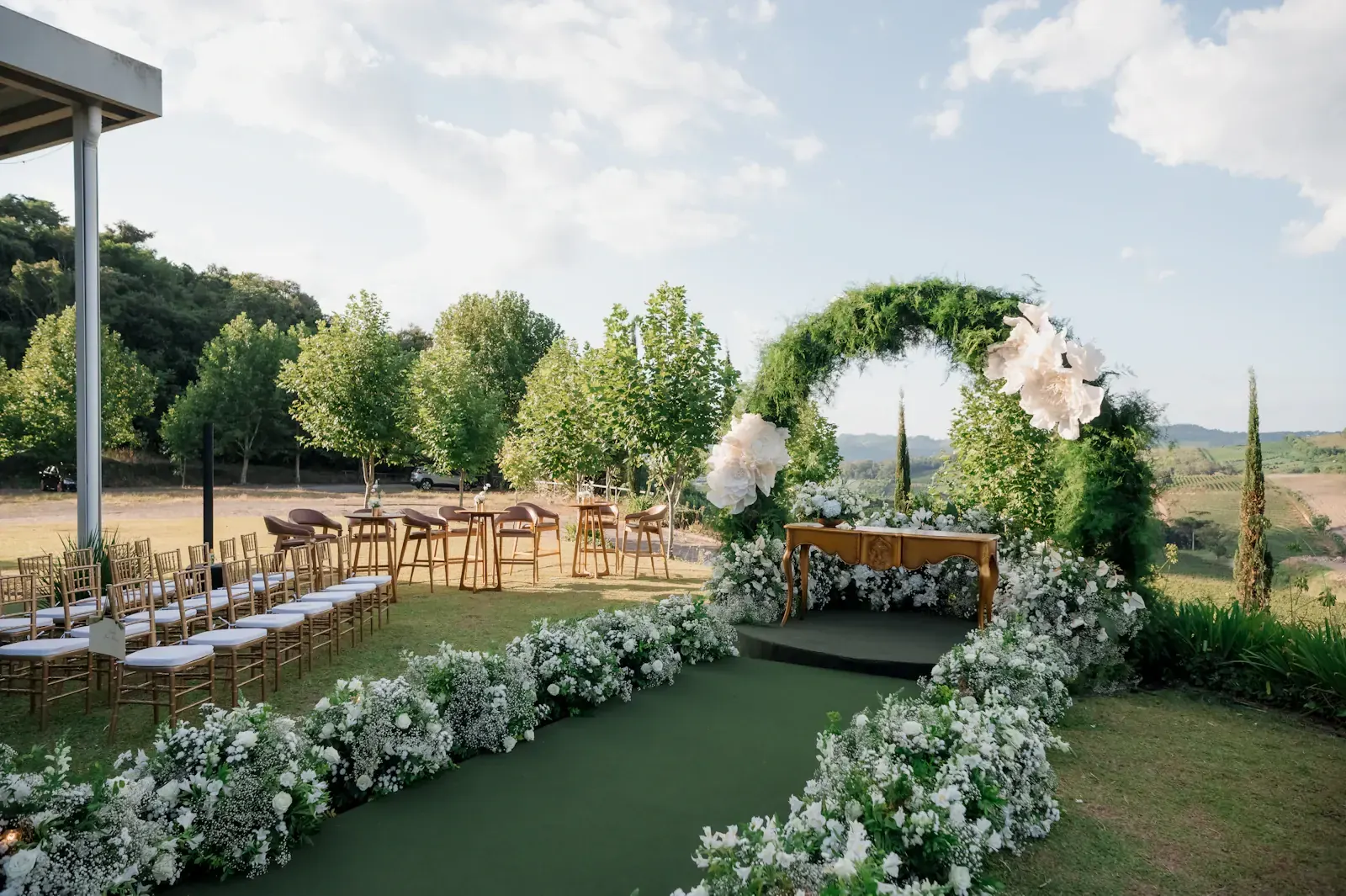 An outdoor wedding ceremony set with a floral arch